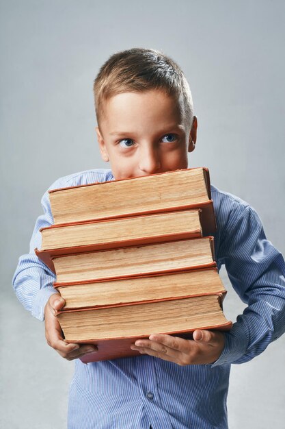 Um retrato de um menino com livros grandes