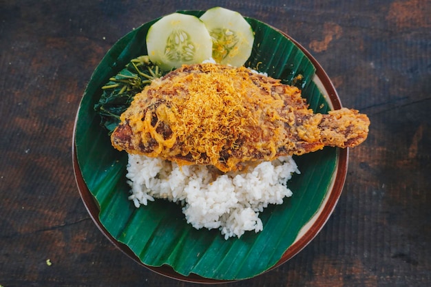 Um retrato de um peixe tilápia frito com legumes de arroz ou lalapan e molho de pimenta ou sambal
