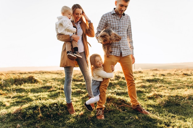 Um retrato de uma família feliz que está jogando no por do sol