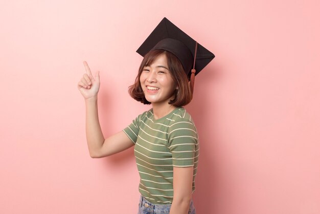 Um retrato de uma jovem estudante asiática com chapéu de formatura.