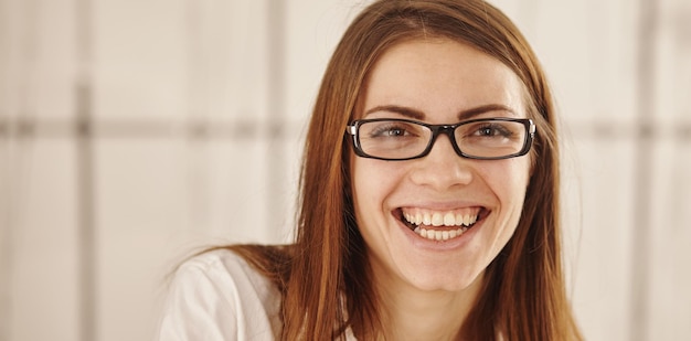 Um retrato de uma jovem linda e sorridente empresária de óculos