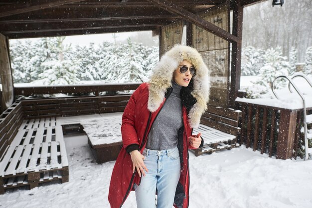 Um retrato de uma linda garota caucasiana em glases ao ar livre no inverno nevado