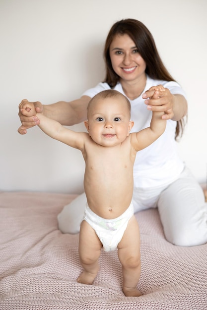 Um retrato de uma linda jovem mãe e seu doce bebê em uma fralda Maternidade Família feliz