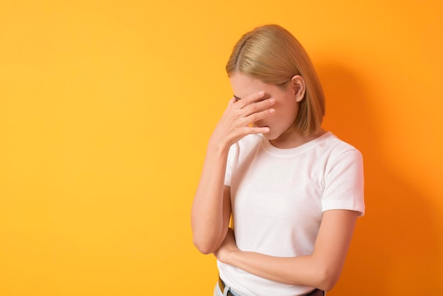 Um retrato de uma mulher de cabelo loiro curto estressada e deprimida no estúdio