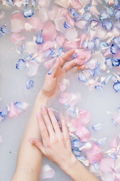 Um retrato sensual de uma mulher em um banho de leite e flores tratamentos de spa para pele macia