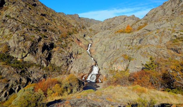 Um rio atravessa um vale com uma montanha ao fundo.