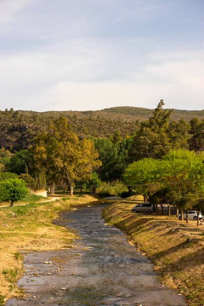 Um rio corre pelas montanhas e as árvores são visíveis