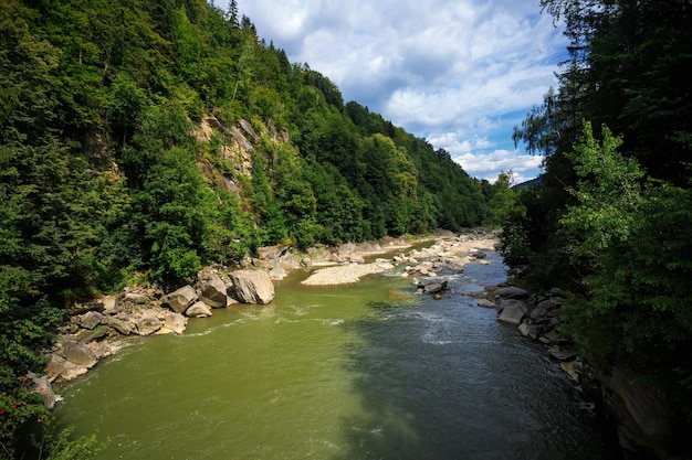 Um rio de montanha com bancos de pedra entre montanhas