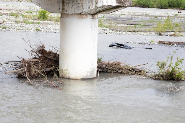 Um rio furioso e galhos de árvores presos no suporte da ponte após fortes chuvas e um furacão