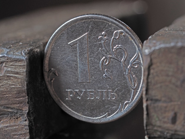 Um rublo russo preso por uma morsa de metal nos dois lados