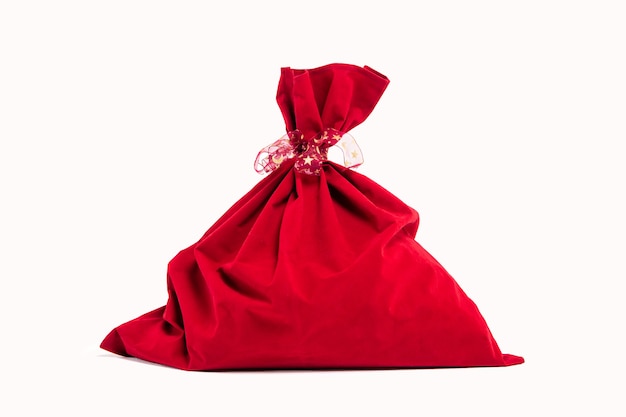 Um saco de veludo vermelho do Papai Noel de Natal para presentes isolados no fundo branco.