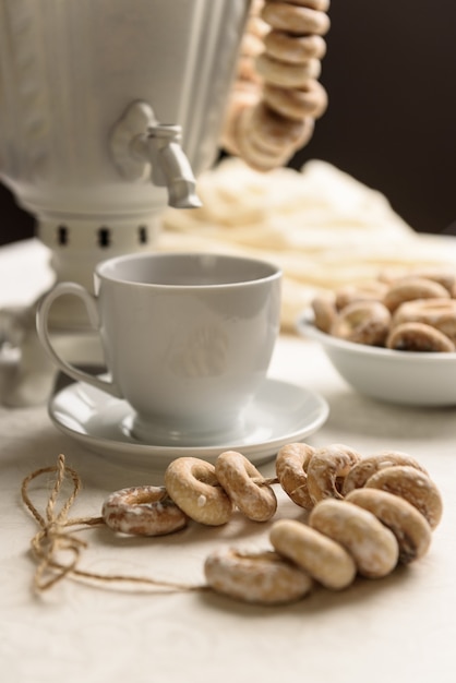 Um samovar com bagels e chá quente na toalha de mesa branca