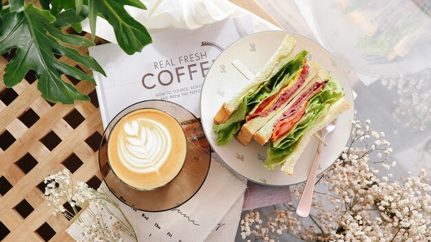 um sanduíche e uma chávena de café estão em uma mesa