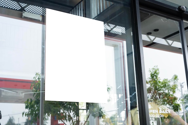Um sinal branco está pendurado em uma janela A cena é ambientada em um edifício com árvores do lado de fora