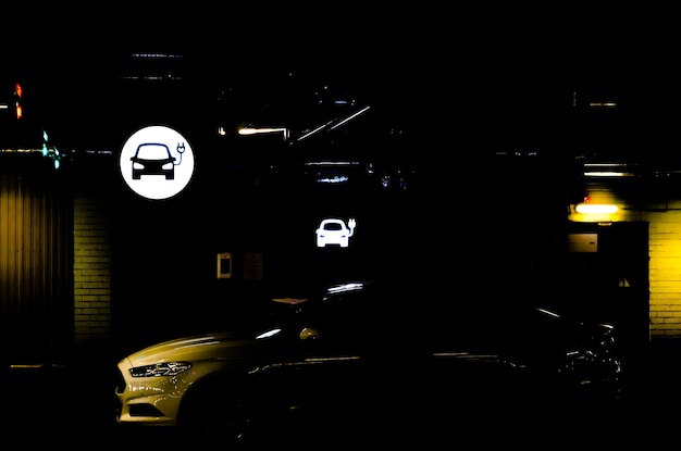 Um sinal de carregamento elétrico de um carro em uma garagem escura.