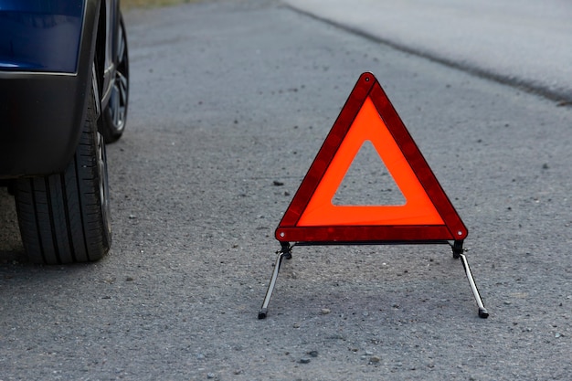 Um sinal de parada de emergência para um veículo está instalado na estrada. Copie o espaço.