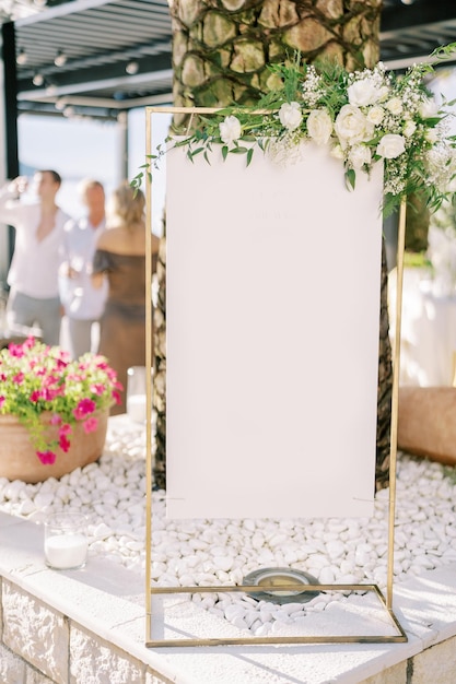 Um sinal em branco em um balcão perto de uma palmeira em um terraço de um restaurante