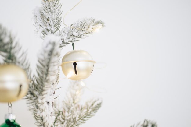 Foto um sino de ouro pendurado num galho de árvore de natal