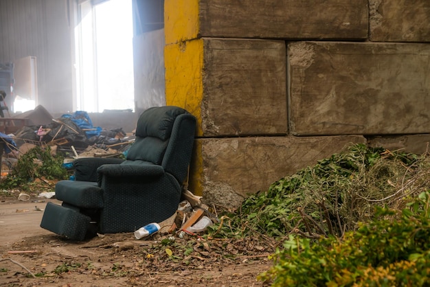 Foto um sofá abandonado e lixo no campo.