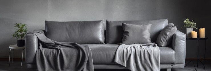 Foto um sofá cinza simples e elegante com um cobertor aconchegante em um ambiente de quarto interior escuro