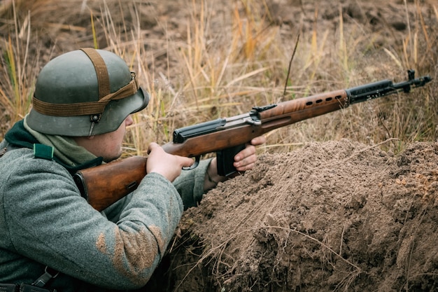 Foto um soldado alemão com um rifle soviético na trincheira