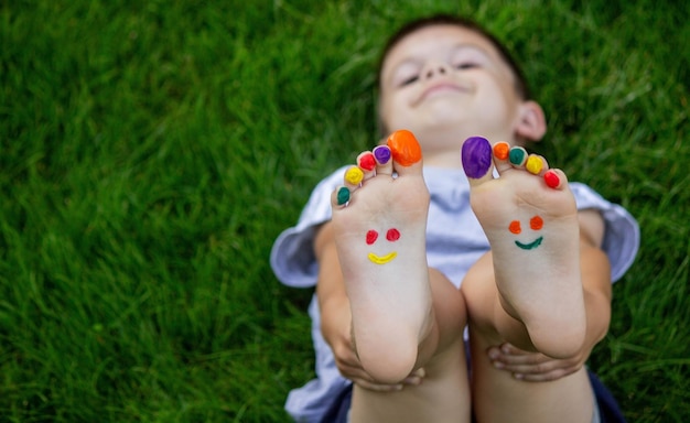um sorriso pintado com tintas nos braços e pernas da criança Foco seletivo