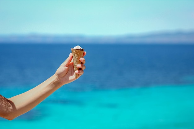 Um sorvete nas mãos perto da beira-mar em viagens de fim de semana na natureza