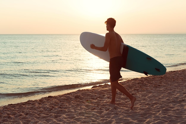 Um surfista ao pôr do sol.