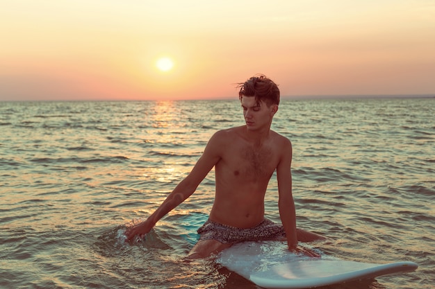 Um surfista ao pôr do sol.