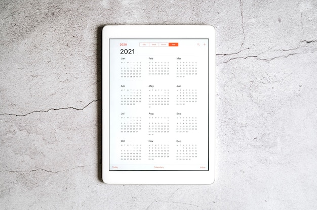 Um tablet com um calendário aberto para 2021 anos em um cinza