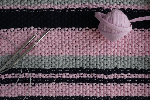 Um tapete feito de fios de malha e agulhas de tricô Bordado em casa