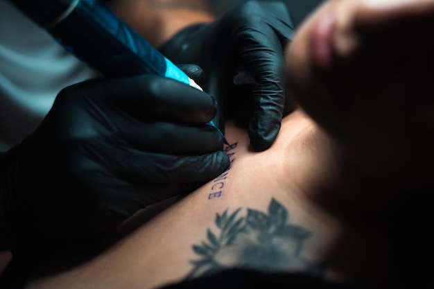 Um tatuador está desenhando uma tatuagem com a palavra paz.