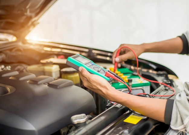 Um técnico está verificando a disponibilidade da bateria do carro.