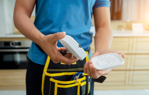 Um técnico instala uma sirene de alarme de segurança em um apartamento moderno