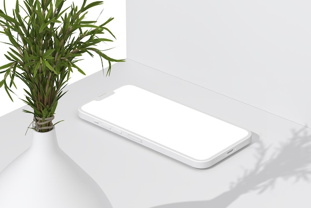 Um telefone branco está sobre uma mesa branca com uma planta no canto.