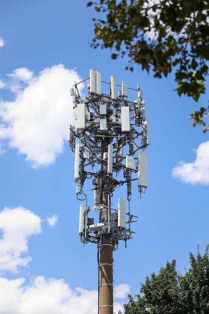 Um telefone com muitos fios ligados a ele está em um céu azul claro.