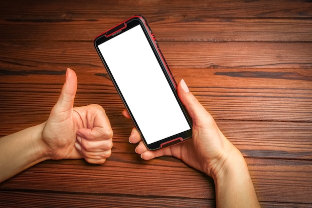 Um telefone com vício nas mãos em uma superfície de madeira