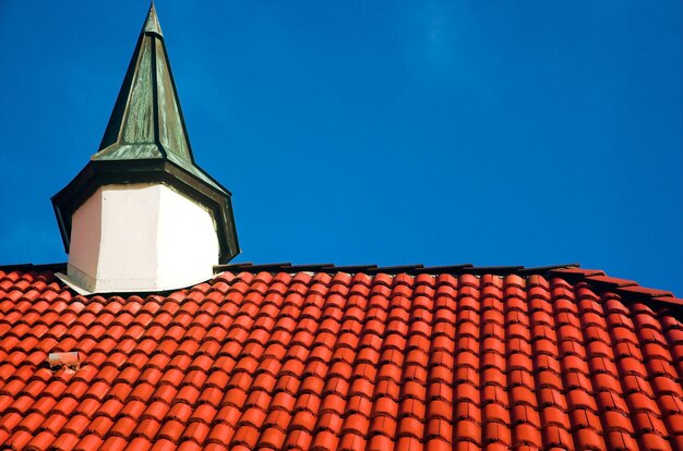 um telhado vermelho com um telhado verde e um telhado branco com um campanário