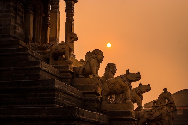 Um templo ensolarado com estátuas de animais no topo