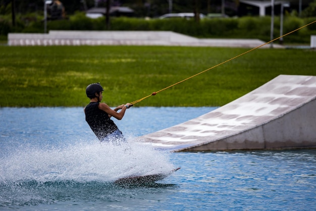 Foto um tipo a fazer wakeboard num lago artificial.