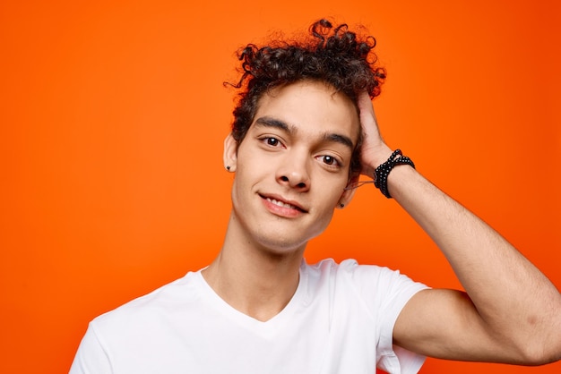 Foto um tipo alegre com uma careta branca em close-up com fundo laranja foto de alta qualidade