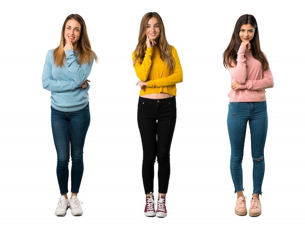 Um tiro completo de um grupo de pessoas com roupas coloridas, sorrindo e olhando para a frente