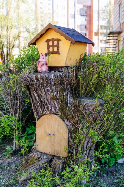 Um toco de árvore com um portão estilizado como uma casa de um esquilo da floresta