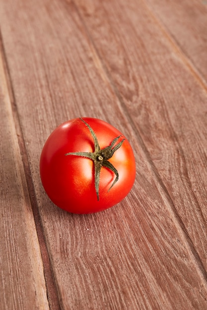 Um tomate maduro em uma placa decorativa.