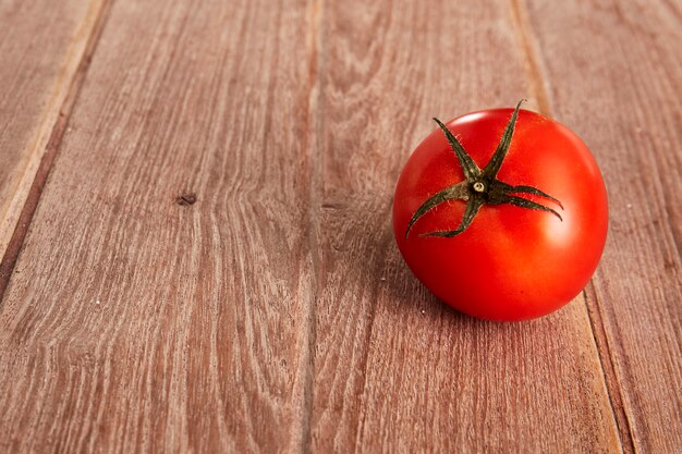 Um tomate maduro em uma placa decorativa.