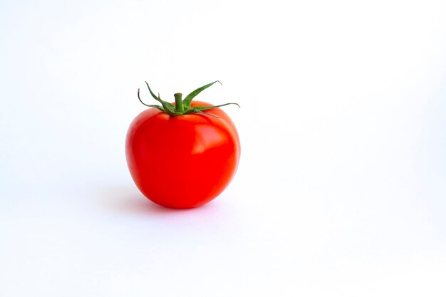 Um tomate vermelho inteiro isolado em um fundo branco