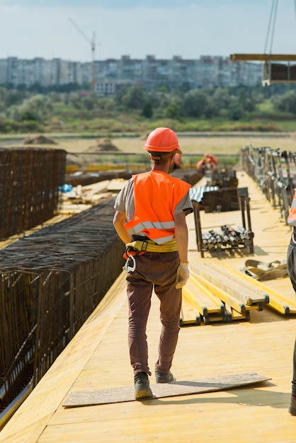 Foto um trabalhador com capacete de segurança caminha pela área de construção