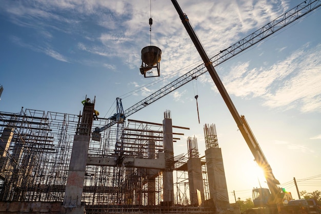 Um trabalhador da construção civil controla uma bomba de concreto, incluindo guindastes no canteiro de obras