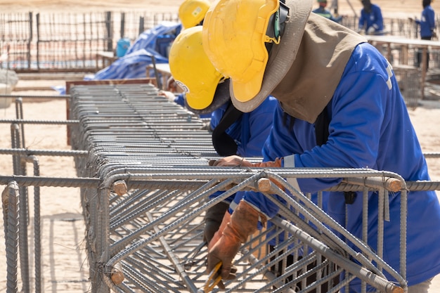 Foto um trabalhador da construção civil fixação barra de aço no canteiro de obras