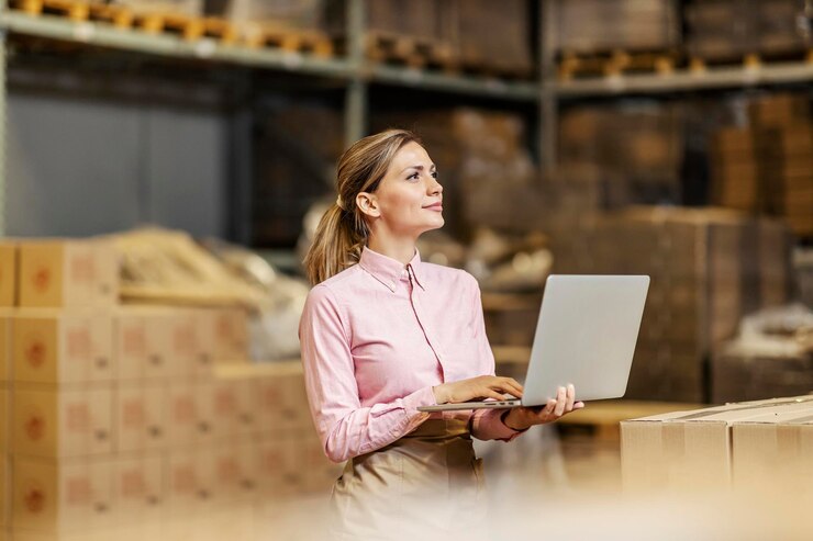 Foto um trabalhador da indústria de alimentos verificando a remessa no laptop no armazém